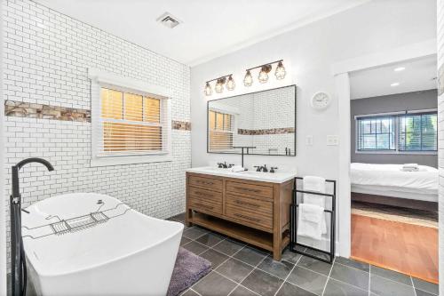 a bathroom with a tub and a sink and a bed at 5 Minutes to Campbell - Clarksville Craftsman in Clarksville