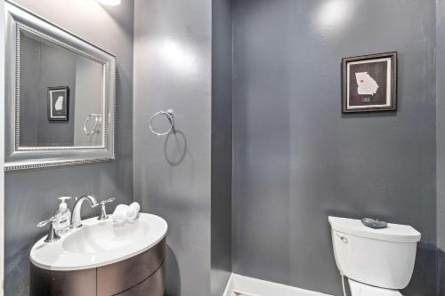 a bathroom with a sink and a toilet and a mirror at 5 Minutes to Campbell - Clarksville Craftsman in Clarksville