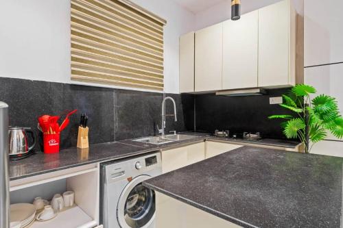 a kitchen with a washing machine and a sink at One bedroom Maisonette Lekki in Lekki