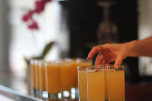 a person reaching for a tray of orange juice at Hôtel de la Grotte in Aix-les-Bains