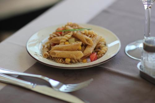 a plate of pasta and vegetables on a table at Hôtel de la Grotte in Aix-les-Bains
