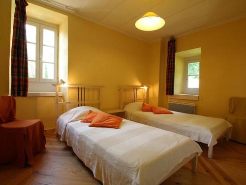 two beds in a room with yellow walls and windows at Maison de campagne avec grande terrasse, près de Lavaudieu et accessible PMR - FR-1-582-217 in Mazerat-Aurouze