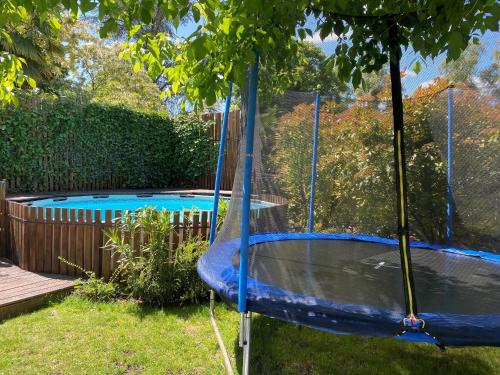 - une balançoire dans une cour à côté d'une piscine dans l'établissement Maison années 30 avec jardin, piscine, proximité Loire, 4 chambres, vélos, idéale familles/amis - FR-1-590-261, à Bonny-sur-Loire