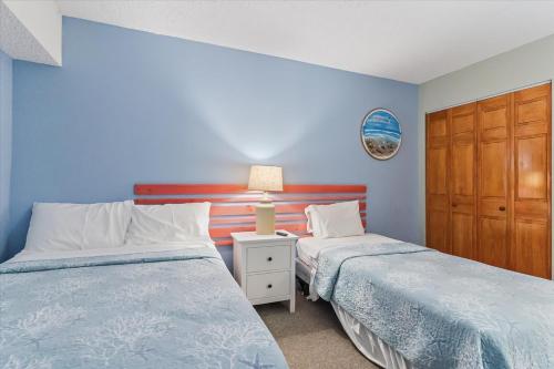a bedroom with two beds and a night stand with a lamp at Ocean View 3BR Condo with Pool in North Ocean City in Ocean City