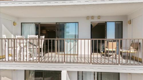 a balcony with chairs and a dog sitting on it at Ocean View 3BR Condo with Pool in North Ocean City in Ocean City