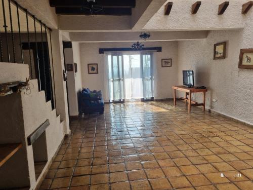 ein Flur mit Fliesenboden und einer Tür mit einem Fernseher in der Unterkunft Casa Marte rústica in Oaxaca de Juárez