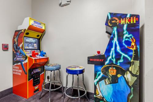 a video game machine and two stools and a monopoly sign at Days Inn by Wyndham Camp Verde Arizona in Camp Verde