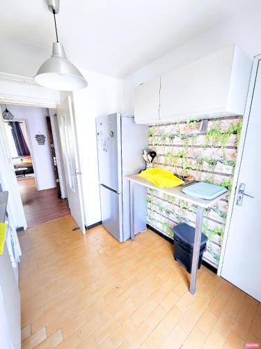 une cuisine avec une table et un réfrigérateur dans l'établissement Doudoute Family Home, à Perpignan