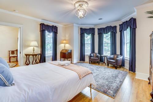 a bedroom with a bed and chairs and windows at Walk to Waterfront Downtown Elizabeth City Home! in Elizabeth City
