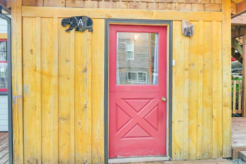 a red door on the side of a wooden building at Salmon Return and Wildlife Roam Ketchikan Getaway! in Ketchikan