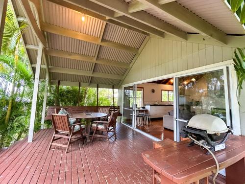 a screened in porch with a grill on a table at Are Ara - House of Pineapple in Titikaweka