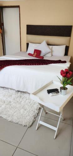 a bedroom with a bed and a table with flowers at A2B Lodge in Durban