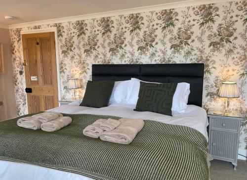 a bedroom with a large bed with towels on it at Treveighan Farmhouse in Saint Teath