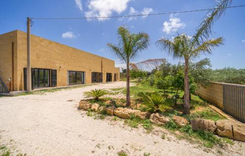 a brick building with palm trees in front of it at Amazing Home In Marsala With Wifi in Marsala