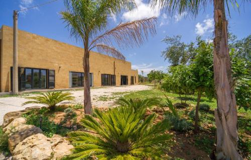 a building with palm trees in front of it at Amazing Home In Marsala With Wifi in Marsala