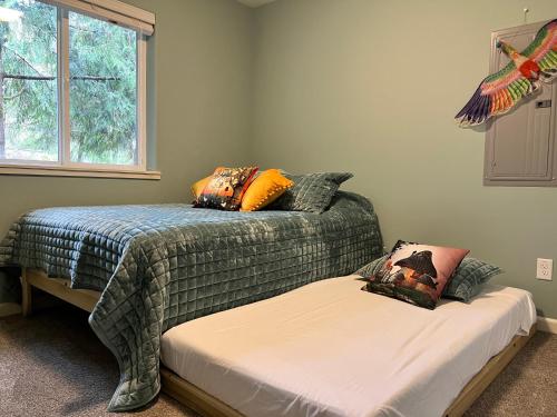 a bedroom with two beds and a window at Forest cottage - secluded, hot tub, walk to beach in Rockaway Beach