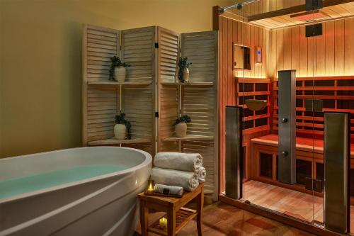 a bathroom with a bath tub and a shower at The Highland Dallas, Curio Collection by Hilton in Dallas