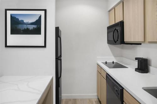a kitchen with a sink and a refrigerator at Homewood Suites by Hilton Fayetteville in Fayetteville