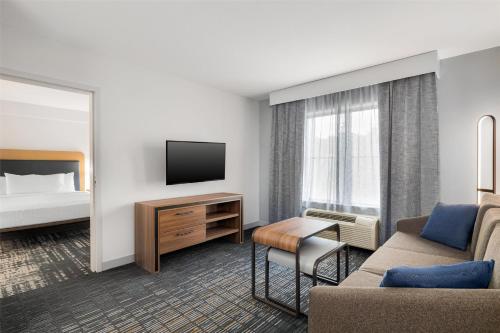 a hotel room with a bed and a television at Homewood Suites by Hilton Slidell in Slidell