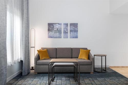 a living room with a gray couch and yellow pillows at Homewood Suites by Hilton Slidell in Slidell