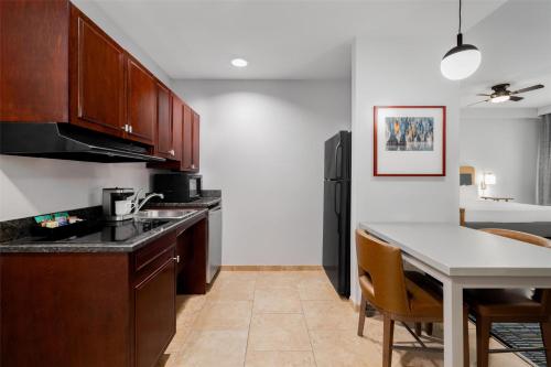a kitchen with a table and a black refrigerator at Homewood Suites by Hilton Slidell in Slidell