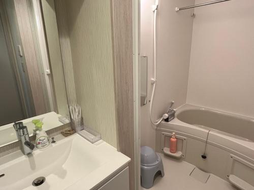 a bathroom with a sink and a tub and a toilet at Toraya Attic in Shimoda