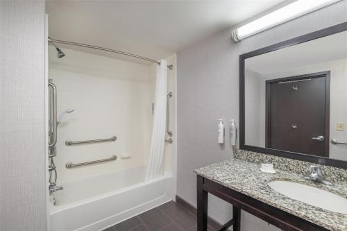 a bathroom with a sink and a shower and a mirror at Hampton Inn Lewiston-Auburn in Lewiston