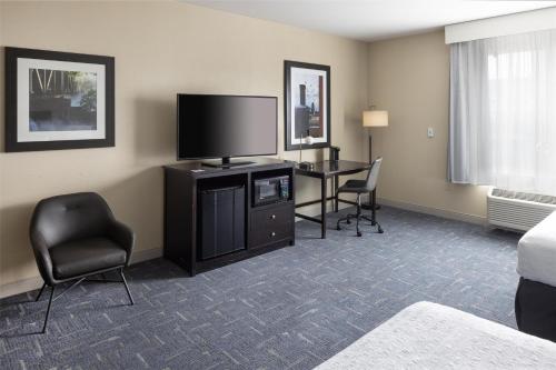 a hotel room with a desk and a flat screen tv at Hampton Inn Lewiston-Auburn in Lewiston
