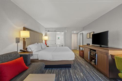 a hotel room with a bed and a flat screen tv at Hampton Inn Toledo-South/Maumee in Maumee