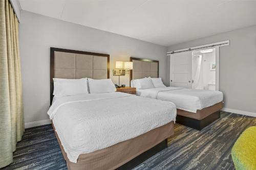 two beds in a hotel room with white sheets at Hampton Inn Toledo-South/Maumee in Maumee