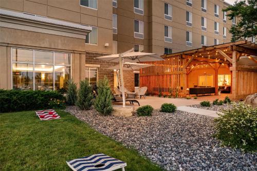 a patio with a table and an umbrella in front of a building at Hilton Garden Inn Billings in Billings
