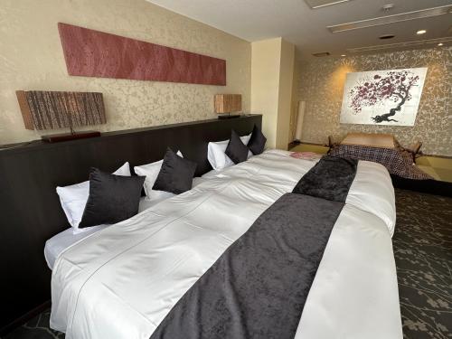 a large white bed in a hotel room at 9STAY Fukui Station in Fukui