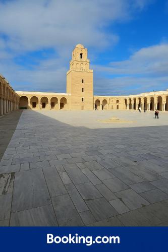 a building with a clock tower in a courtyard at In the heart of the Antic Medina in Kairouan