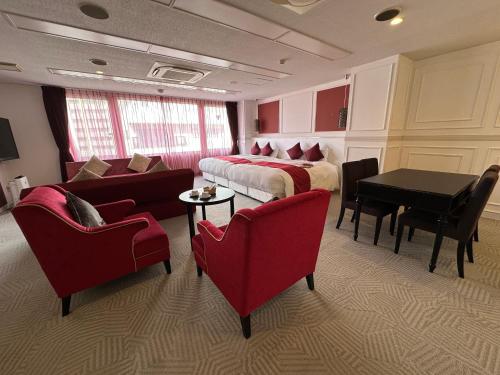 a hotel room with a bed and a table and chairs at 9STAY Fukui Station in Fukui