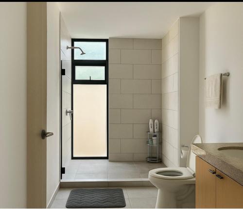 ein Badezimmer mit Dusche, Toilette und Waschbecken in der Unterkunft Dormitorio con baño privado es Tu descanso en el corazón de San Salvador in San Salvador