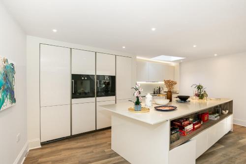 a kitchen with white cabinets and a white counter top at Field House - Stunning 3 Bedroom Home in Kingham! in Kingham