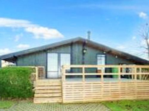 a small house with a wooden deck in front of it at 4 star holiday home in Jægerspris in Jægerspris
