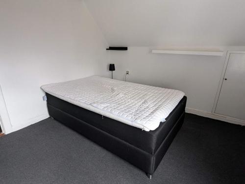 Ce lit se trouve dans un dortoir doté d'un mur blanc. dans l'établissement 5 person holiday home in Tranekær, à Tranekær