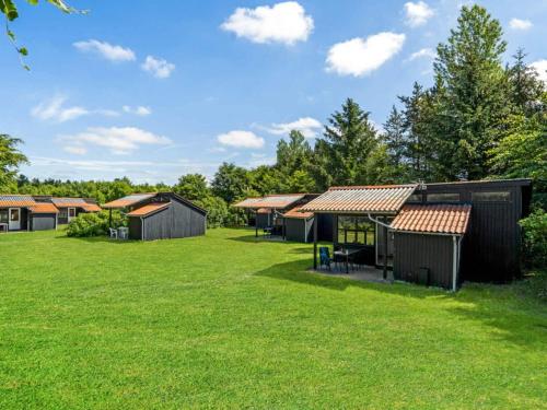 a group of buildings in a field with grass at 4 person holiday home in Hampen in Hampen