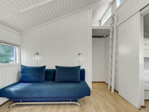 a blue couch in a room with a white wall at 4 person holiday home in Hampen in Hampen
