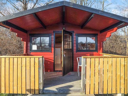 a red house with a wooden door and windows at Holiday home for family Denmark in Gørlev