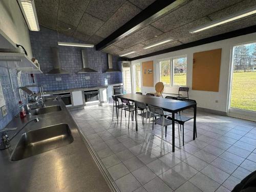 a large kitchen with a table and chairs in it at 4 person holiday home in Hampen in Hampen