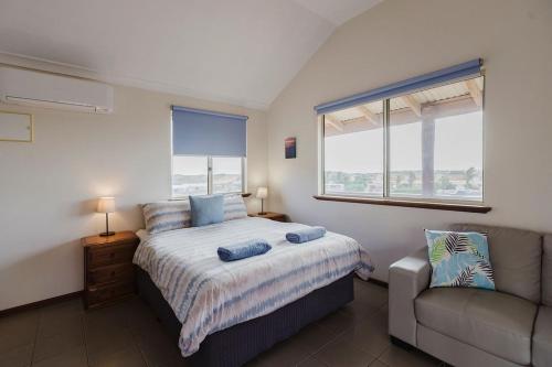 une chambre avec un lit, un canapé et une fenêtre dans l'établissement Peoples Park, à Coral Bay