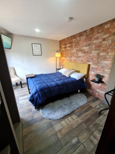 a bedroom with a blue bed and a brick wall at C46-R01 STUDIO at ITESM CEM Families Tourists & Travelers Choice Foreign Students Companies Executives WELCOME!!! 10min Izcalli-15min Esmeralda-20min Sátelite-25min AIFA in Mexico City