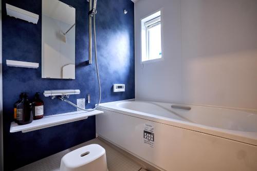 ein Badezimmer mit Badewanne, Toilette und Waschbecken in der Unterkunft ブルースカイ富士 in Fujikawaguchiko