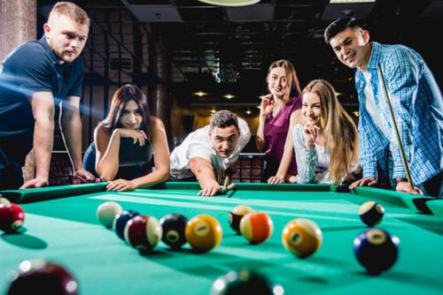 a group of people standing around a pool table at European Hostel Central Pattaya in Pattaya