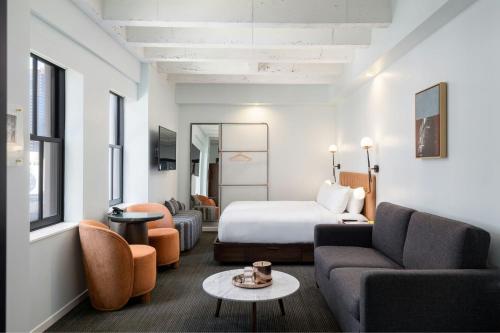 a hotel room with a bed and a couch at The Guild Hotel San Diego Downtown, a Marriott Tribute Portfolio Hotel in San Diego