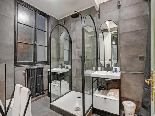 une salle de bain avec deux lavabos et deux miroirs dans l'établissement Charming apartment - 4BR -10P- Madeleine, à Paris