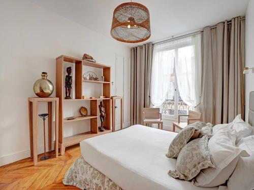 une chambre avec un lit blanc et une fenêtre dans l'établissement Charming apartment - 4BR -10P- Madeleine, à Paris