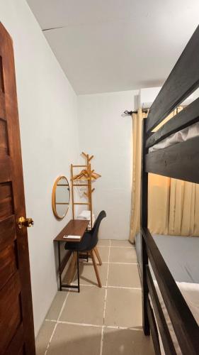 a bedroom with a desk and a bed and a chair at Hidden Leaf Villa in Caoayan